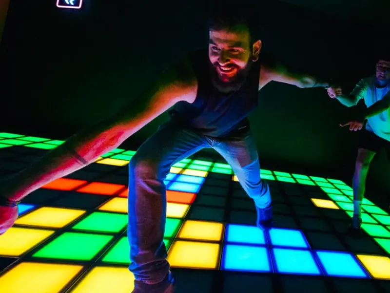 Deux amis rient sur la Grille lumineuse de Pixel Rush